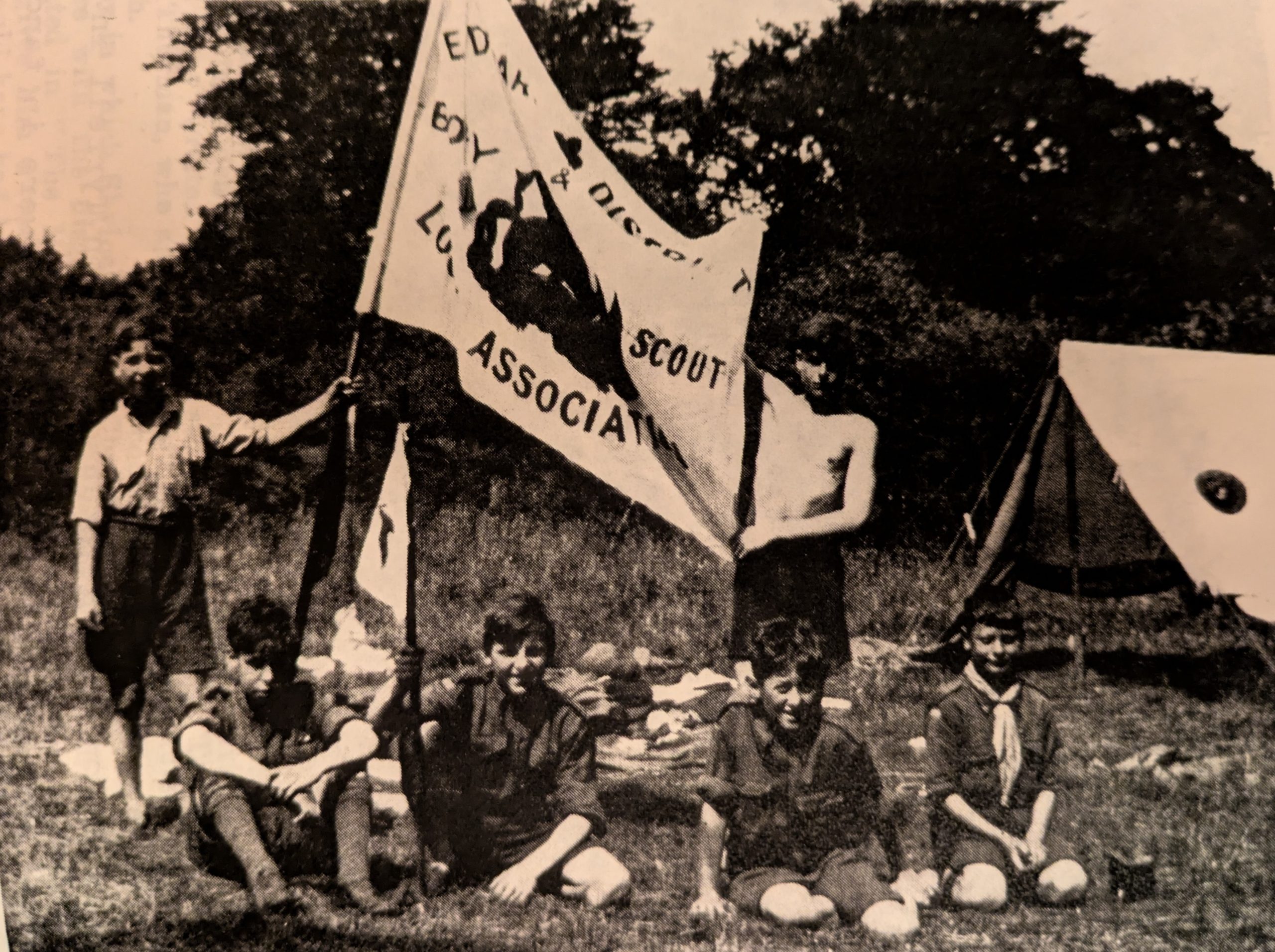 A vintage photo of Scouts on camp, with a flag